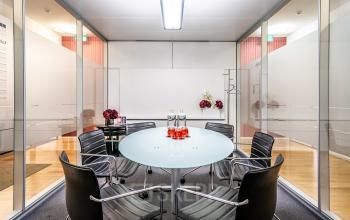 Moderner Konferenzraum mit Glastisch und schwarzen Stühlen im Büro in Unter den Linden 10, ideal für Meetings und Geschäftsbesprechungen in Berlin Mitte. Perfekt zum Büroraum mieten.