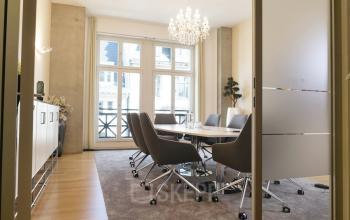 Konferenzraum in Unter den Linden 10, Berlin Mitte, mit modernem Tisch und bequemen Stühlen, ideal um Büroraum zu mieten. Ein heller Kronleuchter und große Fenster vervollständigen den Raum.