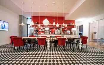 Moderne Pantry mit schwarz-weiß kariertem Boden und roten Akzenten, ideal für informelle Treffen im Büro mieten in Berlin Mitte, Unter den Linden 10.
