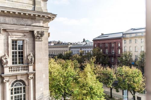 Blick auf historische Fassaden und Bäume entlang der Straße Unter den Linden 10 in Berlin Mitte.