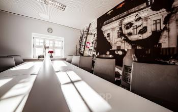 Moderner Besprechungsraum mit großem Konferenztisch, stilvoller Wandgestaltung und viel natürlichem Licht in Berlin Mitte. Ideal, um Bürofläche zu mieten.