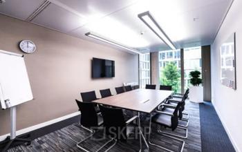 Raum in einem Bürogebäude in Rahel-Hirsch-Straße 10, Berlin Moabit, Berlin. Großer Besprechungstisch mit mehreren Stühlen, Wandbildschirm, Flipchart und viel Tageslicht. Ideal, um Bürofläche zu mieten.