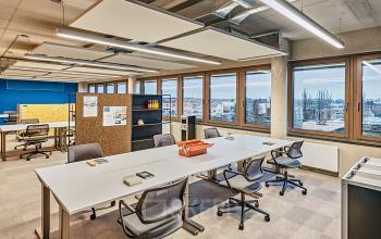 Moderne Bürofläche auf dem EUREF-Campus 22 in Berlin Schöneberg mit großen Fenstern, Blick auf die Stadt und mehreren Arbeitsplätzen. Perfekt zum Büro mieten oder Büroraum mieten.