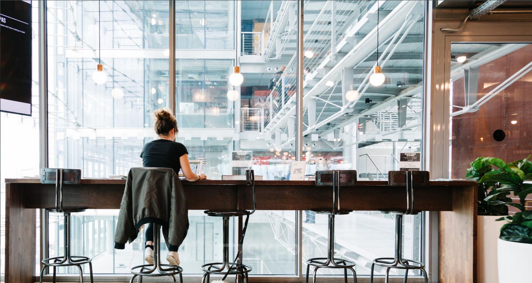 Arbeitsplatz an Glasfassade mit Blick ins Foyer