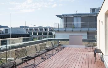 Sonnige Dachterrasse in der Nürnberger Straße 8, Berlin Tiergarten, mit Holzdeck und modernen Stühlen. Perfekte Ergänzung beim Büro mieten für entspannte Pausen im Freien.