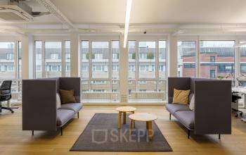 Modernes Büro mieten in der Nürnberger Straße 8, Berlin Tiergarten, mit Sitzmöglichkeiten und großen Fenstern.