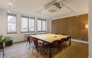 Moderner Besprechungsraum mit Holzwänden und Tisch in der Nürnberger Straße 8, Berlin Tiergarten. Bürofläche mieten in professioneller Atmosphäre.