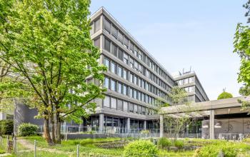 Außenansicht des Bürogebäudes in der Weltpoststrasse 5, Bern, umgeben von Bäumen, ideal zum Büro mieten.