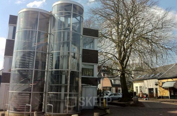 Exterior view of the office building at Zomerzorgerlaan 50, Bloemendaal. The building features unique cylindrical glass staircases.