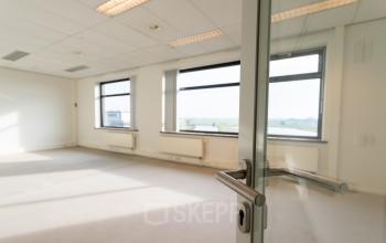 Bright, unfurnished office space available for rent at Tolnasingel 1-3, Bodegraven, with large windows and ample natural light.