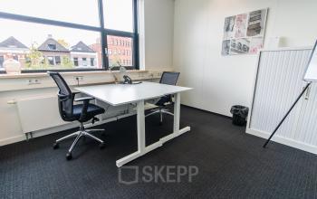 Bright office space at Ceresstraat 1 in Breda Centrum-Station featuring two chairs and a desk with a phone, ideal for office space rental.