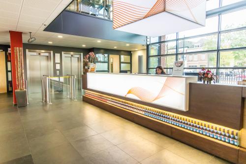 Bright office reception area at Ceresstraat 1, Breda Centrum-Station, featuring modern design with a front desk and seating area, perfect for office space rental.