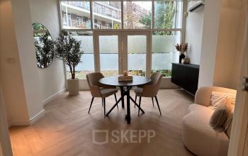 Cozy office space at Sophiastraat 40 40, Breda Centrum-Station, featuring a furnished area with a round table, chairs, and a plush armchair, ideal for office space rental.