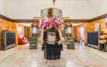 Spacious and elegant office entrance at Ceresstraat 13, Breda Centrum-Station with marble floors and a central floral display. Ideal for those looking to rent office space with a touch of sophistication.