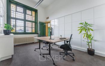 Bright office space at Ceresstraat 13, Breda Centrum-Station, featuring a large window and minimal furnishings, ideal for rent office space seekers.