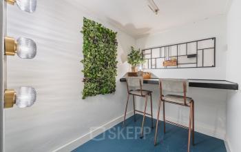 Chic office space to rent at Ceresstraat 13, Breda Centrum-Station, featuring a stylish vertical garden wall and a sleek desk with high chairs, perfect for office space rental seekers.