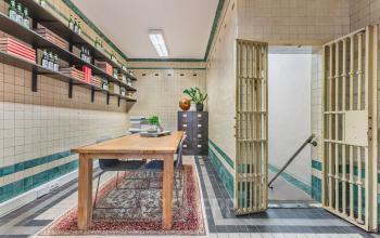 Furnished office space at Ceresstraat 13 in Breda Centrum-Station with wooden desk, shelves, and decorative items. An ideal spot for office space rental with a vintage look.