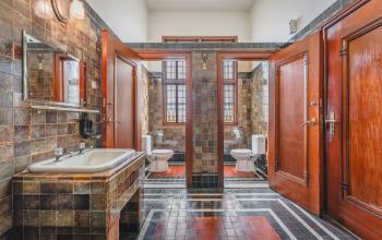 A restroom at Ceresstraat 13, Breda Centrum-Station featuring a vintage tile design and wooden doors, suitable for office space rental needs.