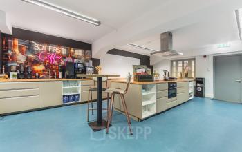 Modern office pantry at Ceresstraat 13, Breda Centrum-Station, featuring sleek countertops and a neon sign, ideal for rent office space.