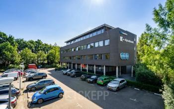 Exterior view of the office building at Westboek 36-66 in Breda Noord-West, featuring modern architecture and ample parking space for easy access to office space rental opportunities.