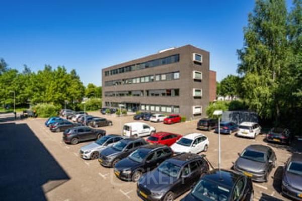 Exterior view of Westboek 36-66 in Breda Noord-West, featuring a modern office building with ample parking space in the foreground. Ideal location for office space rental.