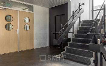 Interior view at Druivenstraat 25-31 in Breda Oost featuring a staircase and elevator, ideal for office space rental.