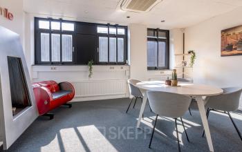 Bright office space at Druivenstraat 25-31 in Breda Oost, featuring a round table with contemporary chairs and natural light streaming in. Ideal for office space rental.