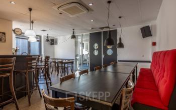 Furnished office space available for rent at Druivenstraat 25-31, Breda Oost, featuring a versatile open floorplan with seating areas and wooden furniture.