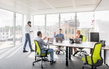 Bright office space featuring large windows and modern furnishings at Leonardo Da Vincilaan 1, Brussels Airport. Rent office space for business meetings and discussions.