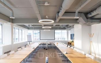 Office to rent at Pegasuslaan 5, Brussels Airport featuring a well-lit conference room with large tables and chairs, ideal for office space rental.