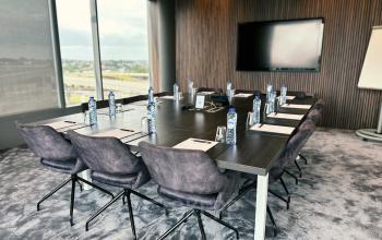 Modern meeting room with a large table, office chairs, and a wall-mounted TV at Leonardo Da Vincilaan 19, Brussels Airport for office space rental.