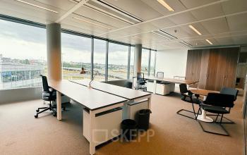 Modern office space to rent at Leonardo Da Vincilaan 19, Brussels Airport with large windows, desks, and office chairs.