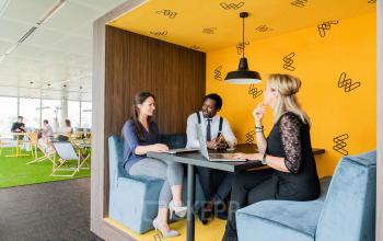 Moderne kantoorruimte te huur op Davincilaan 1 in Brussel Airport met medewerkers die in een gezellige hoek vergaderen. Voorzien van comfortabele zitplaatsen en een aangename, inspirerende omgeving.