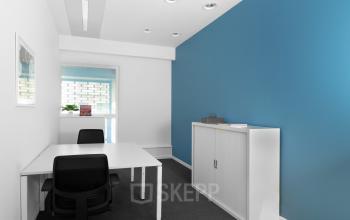 Office space for rent at Koloniënstraat / Rue des Colonies 11, Brussels Center, featuring modern white desks, black chairs, and a blue accent wall.