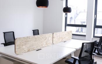 Kantoorruimte te huur op Rue du Congres 37 in Brussel, met moderne werkplekken, bureaustoelen en natuurlijk licht via grote ramen.