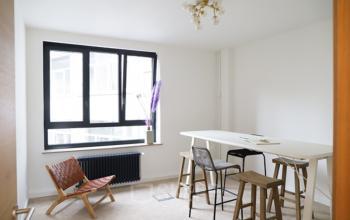 Kantoorruimte te huur aan Rue du Congres 37, Brussel, met modern meubilair en natuurlijke lichtinval door een groot raam.