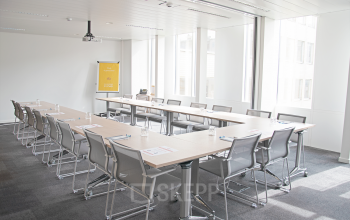 Spacious, well-lit conference room at office space rental location, Louizalaan / Avenue Louise 143, Brussels Elsene, featuring large windows and modern furnishings.