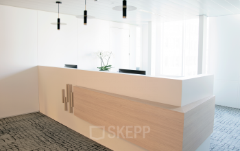Modern reception desk with minimalist design and bright lighting at an office space rental location in Louizalaan / Avenue Louise 143, Brussels Elsene.