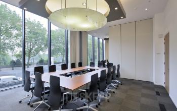 Lichte vergaderruimte met grote ramen, uitzicht op de Louizalaan in Brussel Elsene. Moderne stoelen en tafel, ideale kantoorruimte te huur voor meetings. Perfect om kantoorruimte te huren.