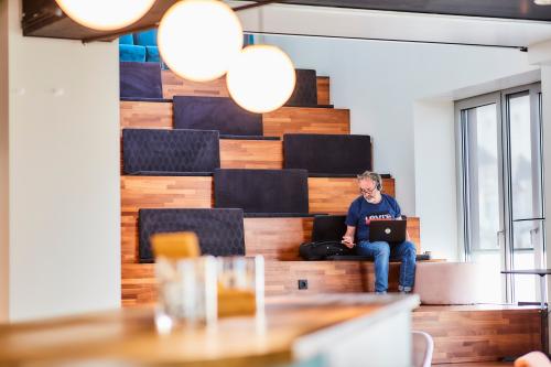Open lounge area with tiered wooden seating and natural light at office space rental on Louizalaan / Avenue Louise 54, Brussels Elsene.