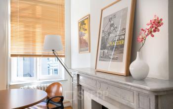 Office space at Louizalaan / Avenue Louise 367 in Brussels Elsene featuring a window with blinds, wall art, a lamp, table, and chair.