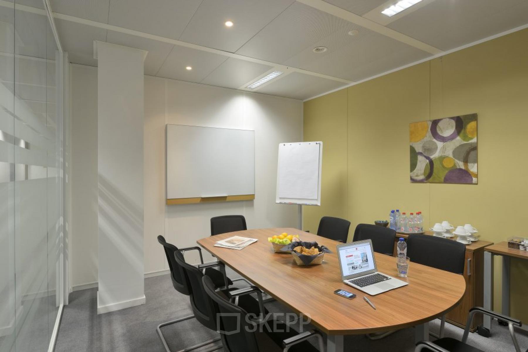 Modern ingerichte vergaderruimte voorzien van een grote tafel, comfortabele stoelen en diverse versnaperingen, gelegen op Schumanplein in Brussel. Ideaal voor wie kantoorruimte wil huren.