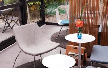 Kantoor te huur op Priester Cuypersstraat 3, Brussel Etterbeek: lichte, moderne lounge met comfortabele stoelen en tafels, uitkijkend op een tuin.