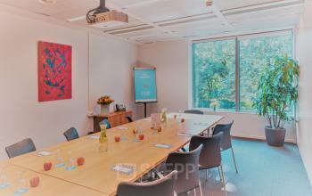 Vergaderruimte te huur op Meeûssquare / Square de Meeûs 38-40, Brussel Europese Wijk. Grote tafel met stoelen en presentatieapparatuur.