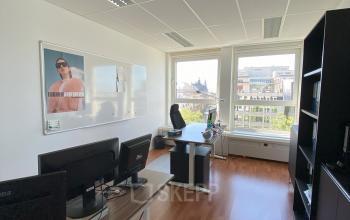 Kantoorruimte te huur in Brussel Europese Wijk, gelegen op Avenue des Arts 3-5. Moderne inrichting met houten vloer, bureaus en grote ramen met stadszicht.