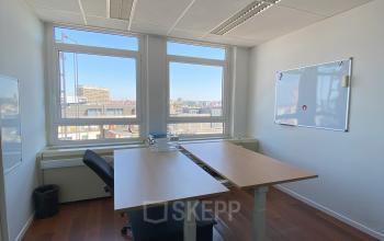 Lichte kantoorruimte te huur in de Europese Wijk, Brussel, met grote ramen, houten vloer en een zit-sta bureau. Ideaal voor productief werken aan Avenue des Arts 3-5.