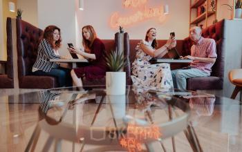 Cozy coworking area at Robert Schumanplein 2-4, Brussels European District with people engaged in discussions, ideal for office space rental.