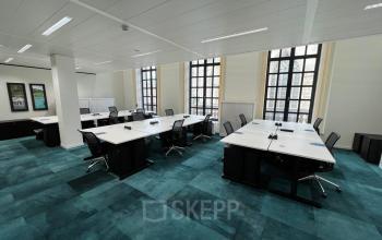 Ruime kantoorruimte te huur op Rue des Colonies 56, Brussel Europese Wijk, met grote ramen en blauwe vloertapijten. Verschillende bureaus en stoelen klaar voor gebruik in een lichte omgeving.