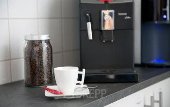 Koffiehoek in een kantoor te huur aan de Breydelstraat / Rue Breydel 34-36, Brussel, Europese Wijk, met een koffiemachine en een pot koffiebonen op het aanrecht.