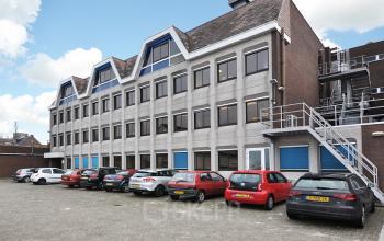 Modern office space rental at Kanaalweg 33, Capelle aan den IJssel, with parked cars outside the multi-windowed facade.